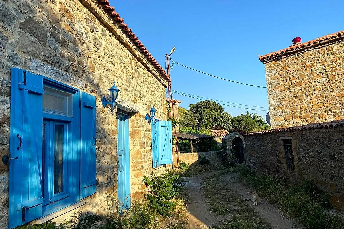 Blue shutters on a stone house in a Gökçeada village
