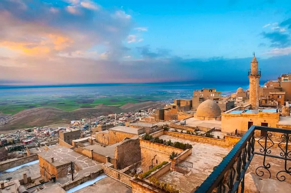 Mardin's stone rooftops and minaret above the plains of Mesopotamia