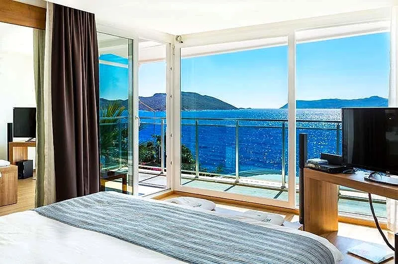 A hotel room with a balcony over the sea