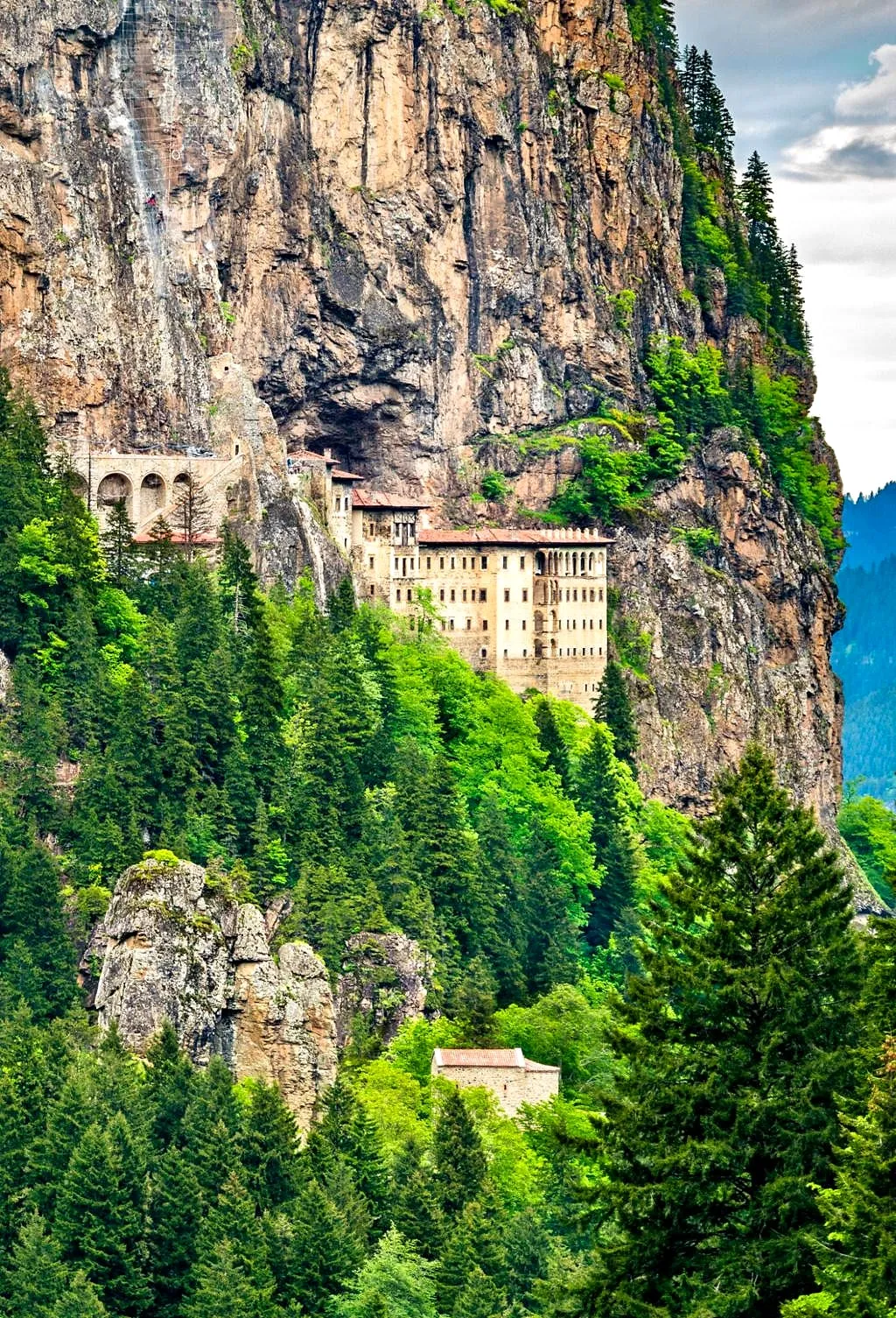 Sümela Monastery clinging to a cliff above a forested valley